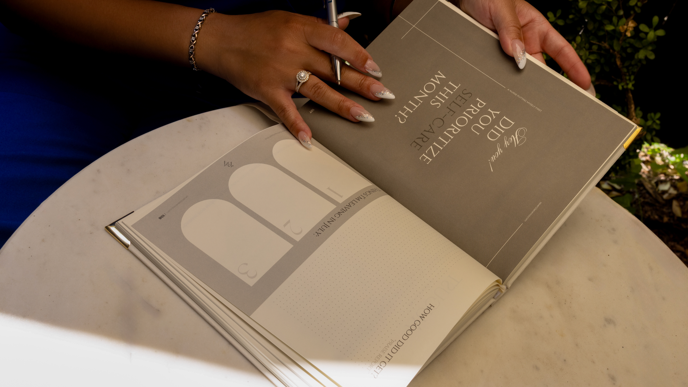 Person holding an open book with a pen on a light surface1621243260e1af0c20-0